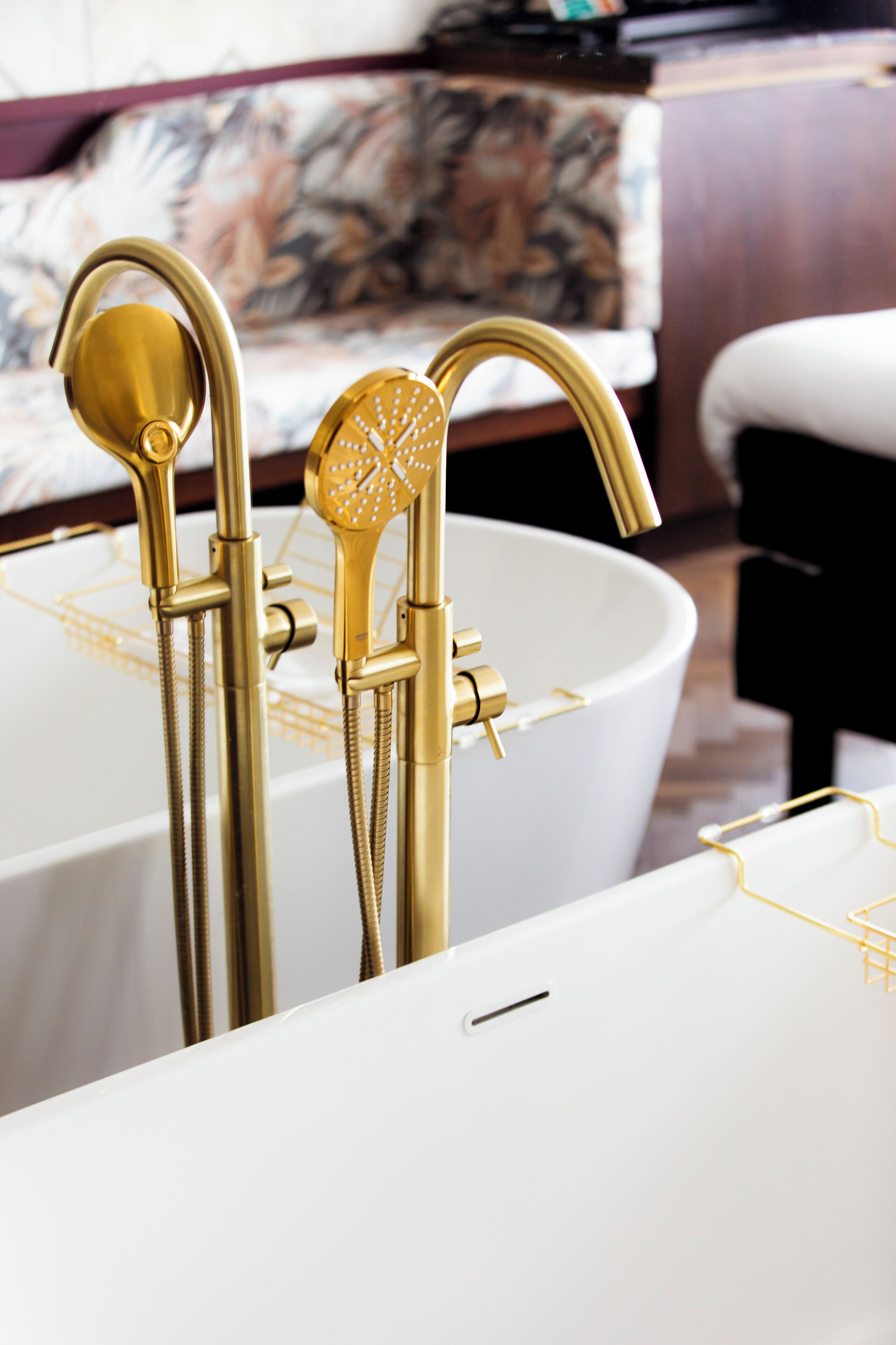 A modern bathroom with gold fixtures and a white bathtub.