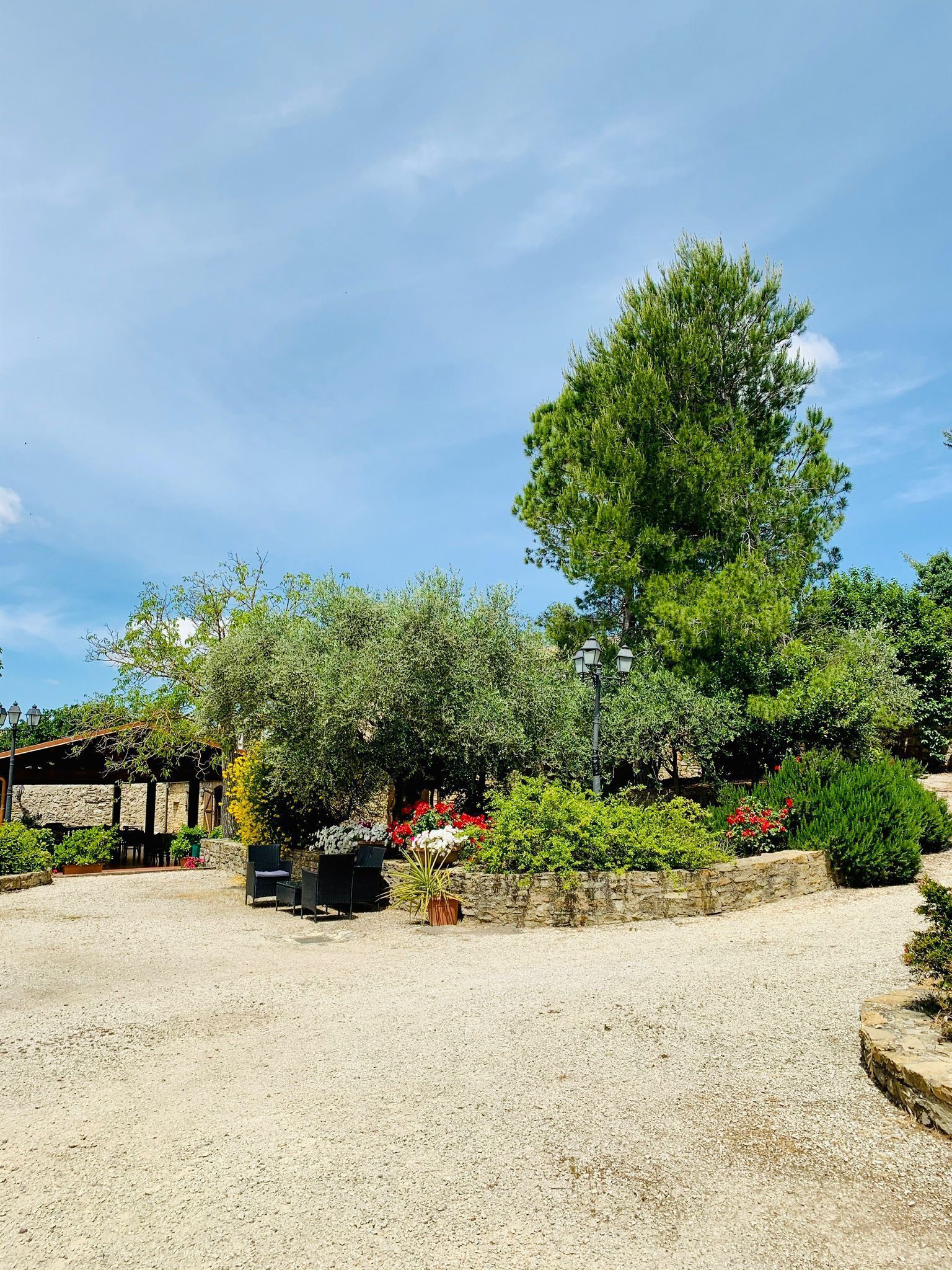A garden area with a stone wall, a pergola, and outdoor seating.