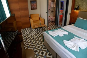 A hotel room with a bed, a chair, a desk, and a bathroom visible through a glass door. - Pera Luna Residence - Special Class (Istanbul)