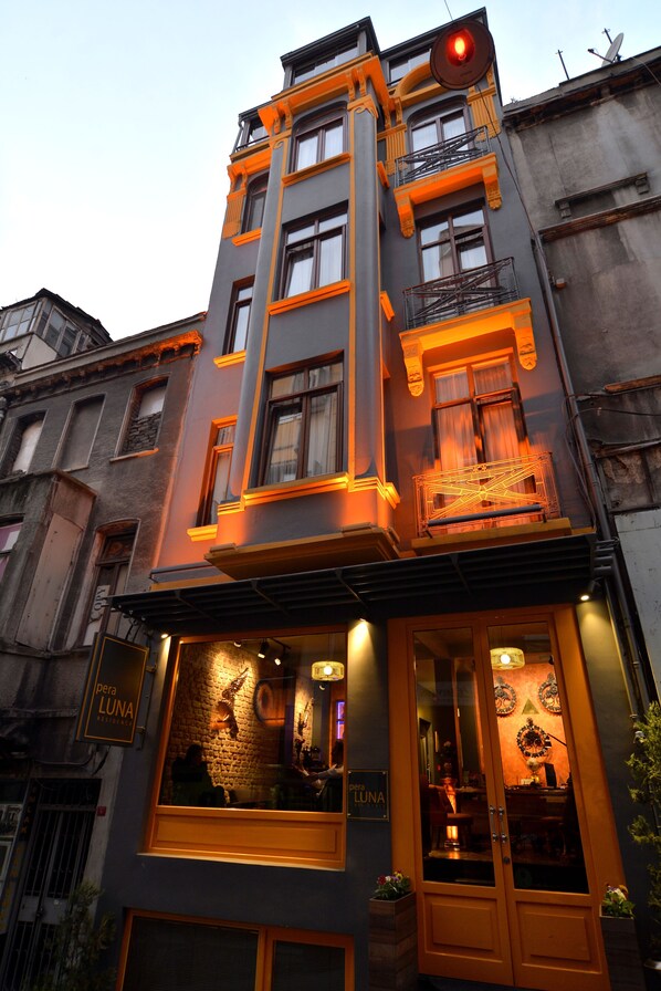 A building with a prominent entrance, large windows, and a balcony with a railing. - Pera Luna Residence - Special Class (Istanbul)