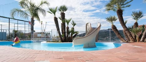 Una piscina cubierta, una piscina al aire libre de temporada, sombrillas