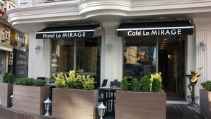 L'hôtel Le MIRAGE et le café Le MIRAGE disposent d'une terrasse et de jardinières décoratives.