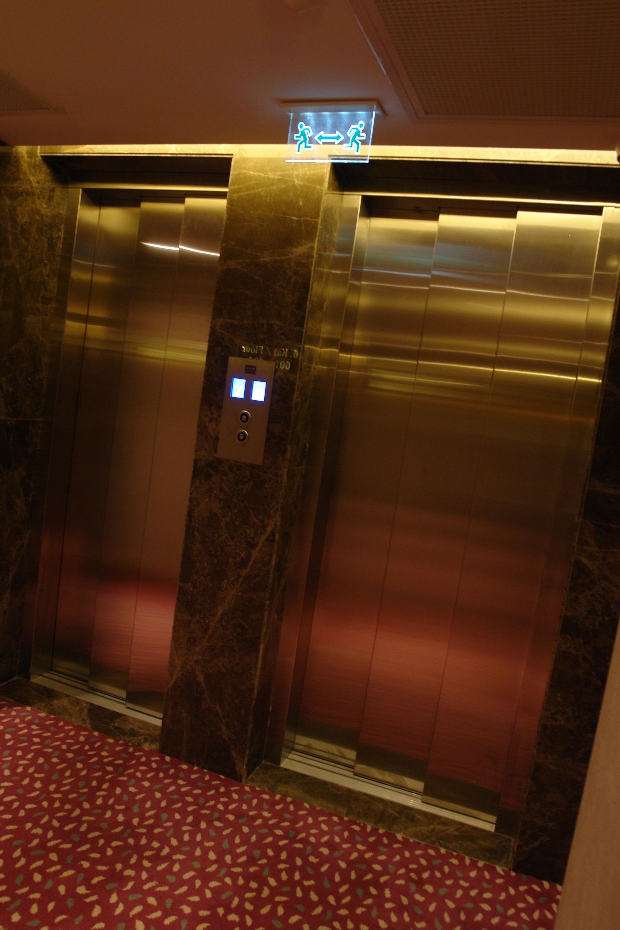 An elevator with a marble finish and a digital display.