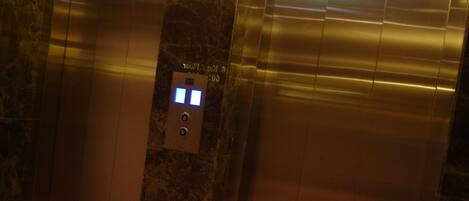 An elevator with a marble finish and a digital display.