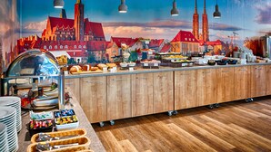 A buffet with various food items and a mural of a cityscape in the background. - Boutique Hotel's Kwiska / Legnicka (Wroclaw)