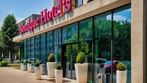 A modern hotel building with large glass windows and a sign reading "Boutique Hotels". - Boutique Hotel's Kwiska / Legnicka (Wroclaw)