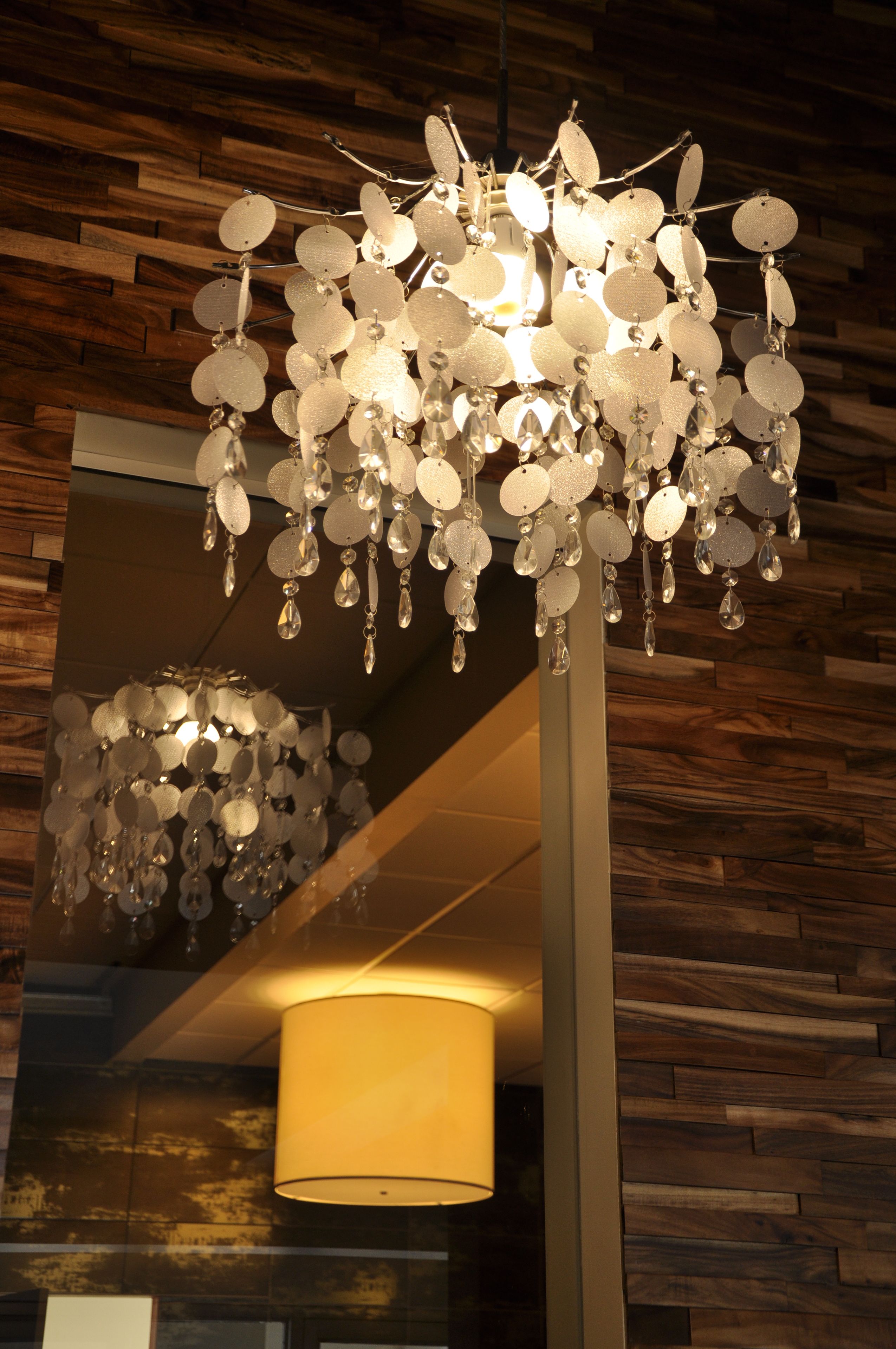 A chandelier with multiple hanging elements and a lamp with a cylindrical shade.
