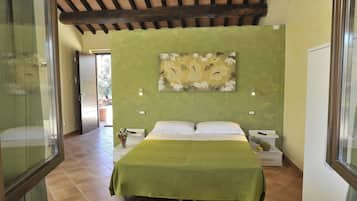 Un dormitorio con cama, paredes verdes y techo con vigas a la vista.
