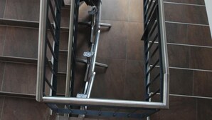 Een modern interieur met een metalen trap en een leuning.