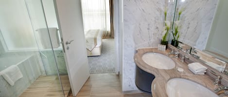 A modern bathroom with a glass shower enclosure, a double sink vanity, and a large mirror.