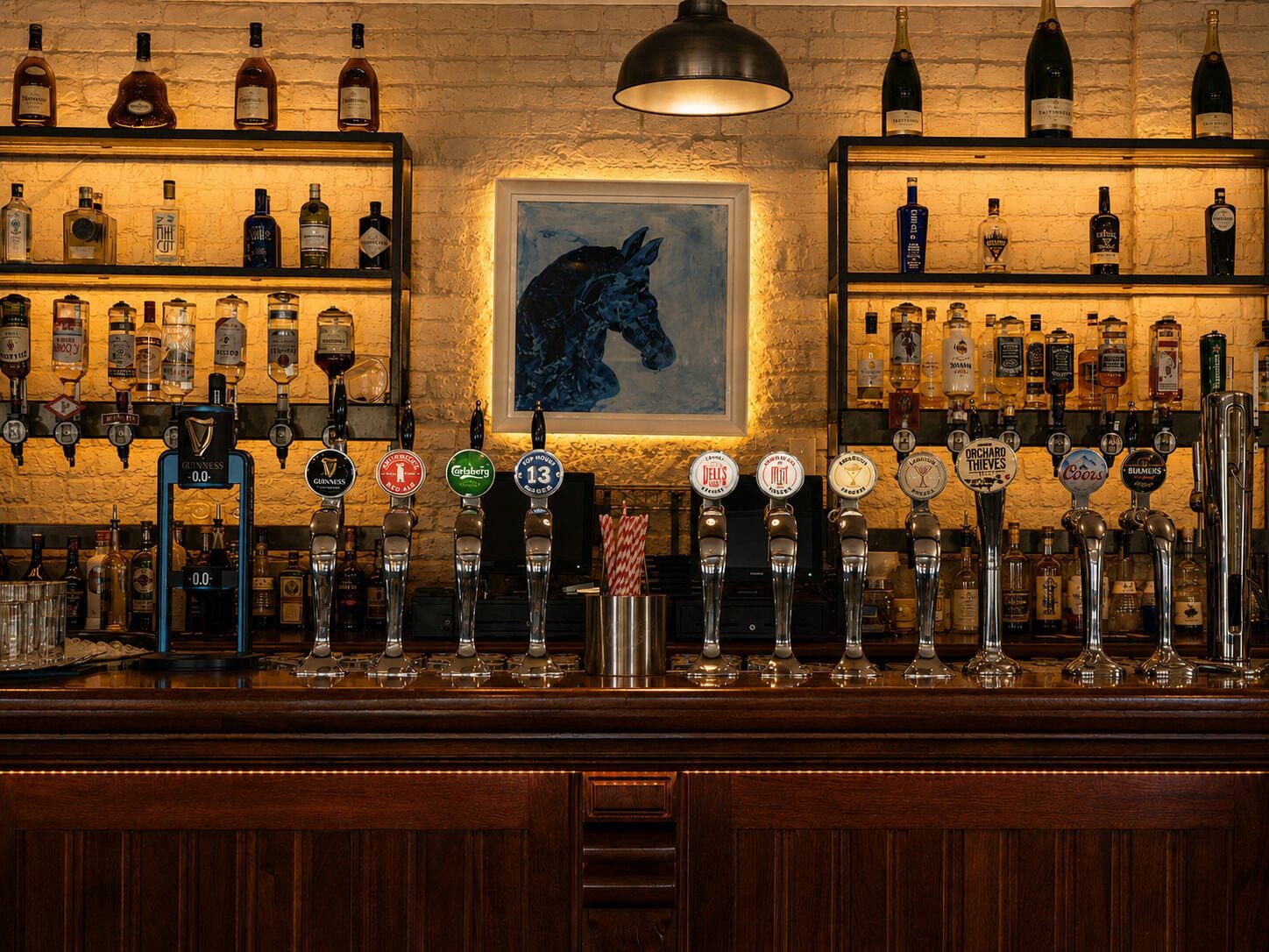 Un bar con varias botellas de licor y grifos de cerveza.