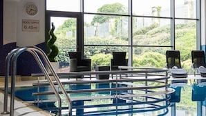 An indoor swimming pool with a clear view of the surrounding landscape through large windows. - Talbot Hotel Clonmel (Clonmel)