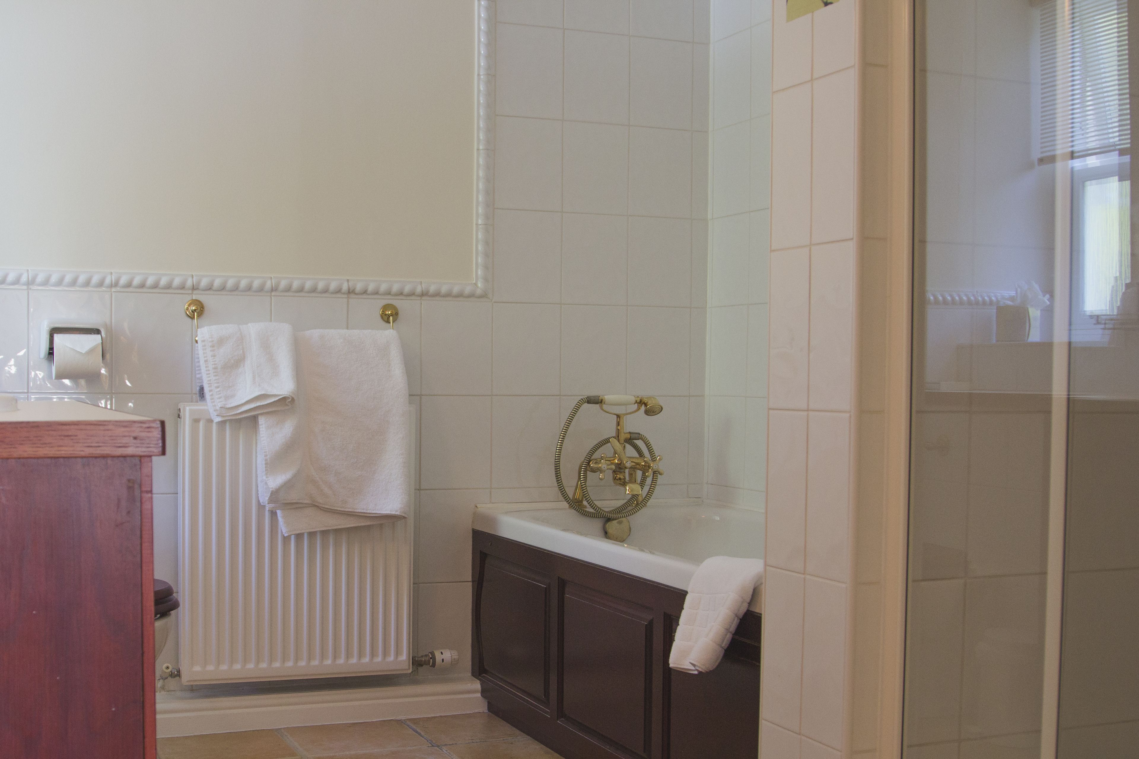 Un bagno con una vasca, un water, un termosifone e un portascope.