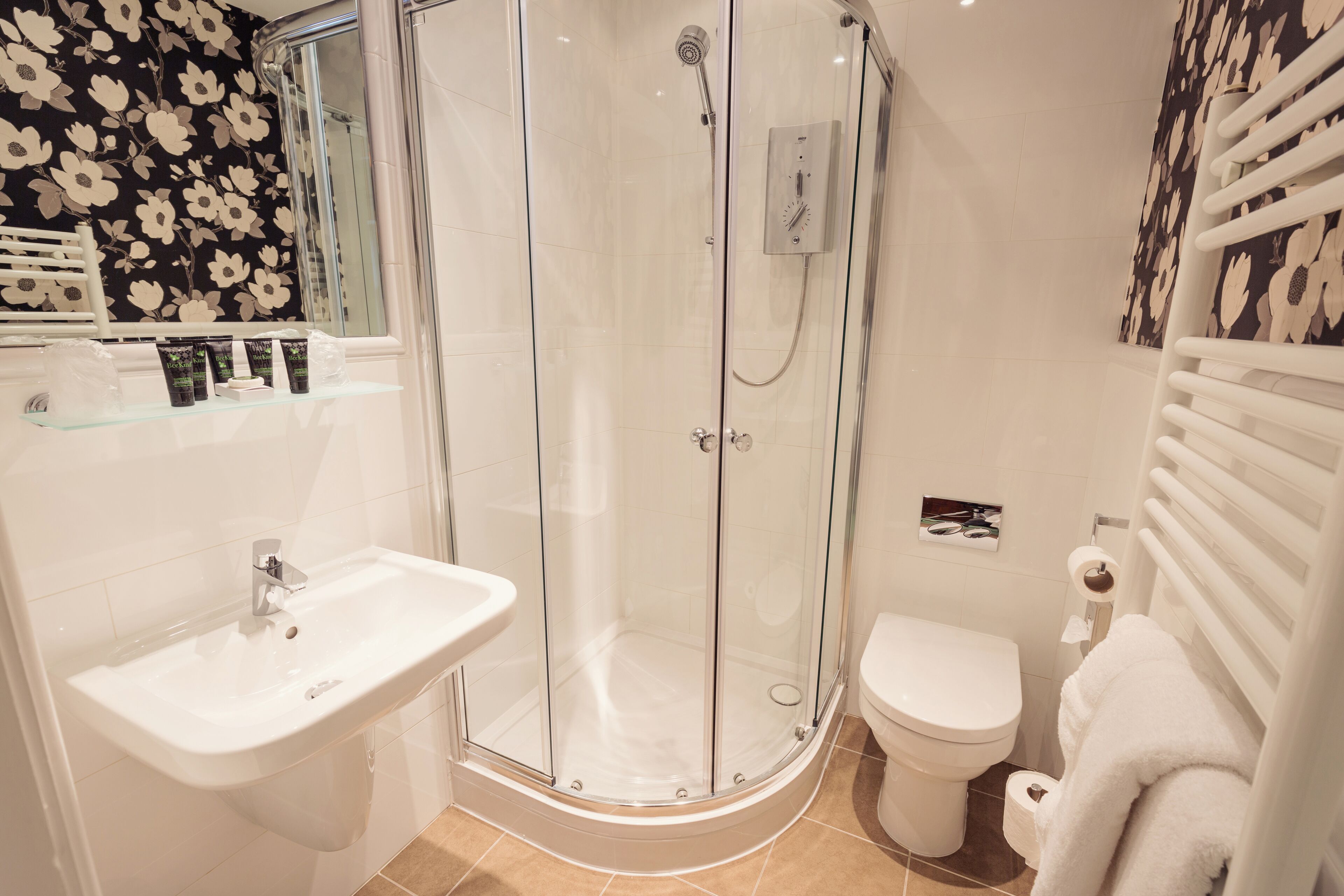Ein modernes Badezimmer mit einer Duschkabine, einem weißen Waschbecken und einer Toilette.