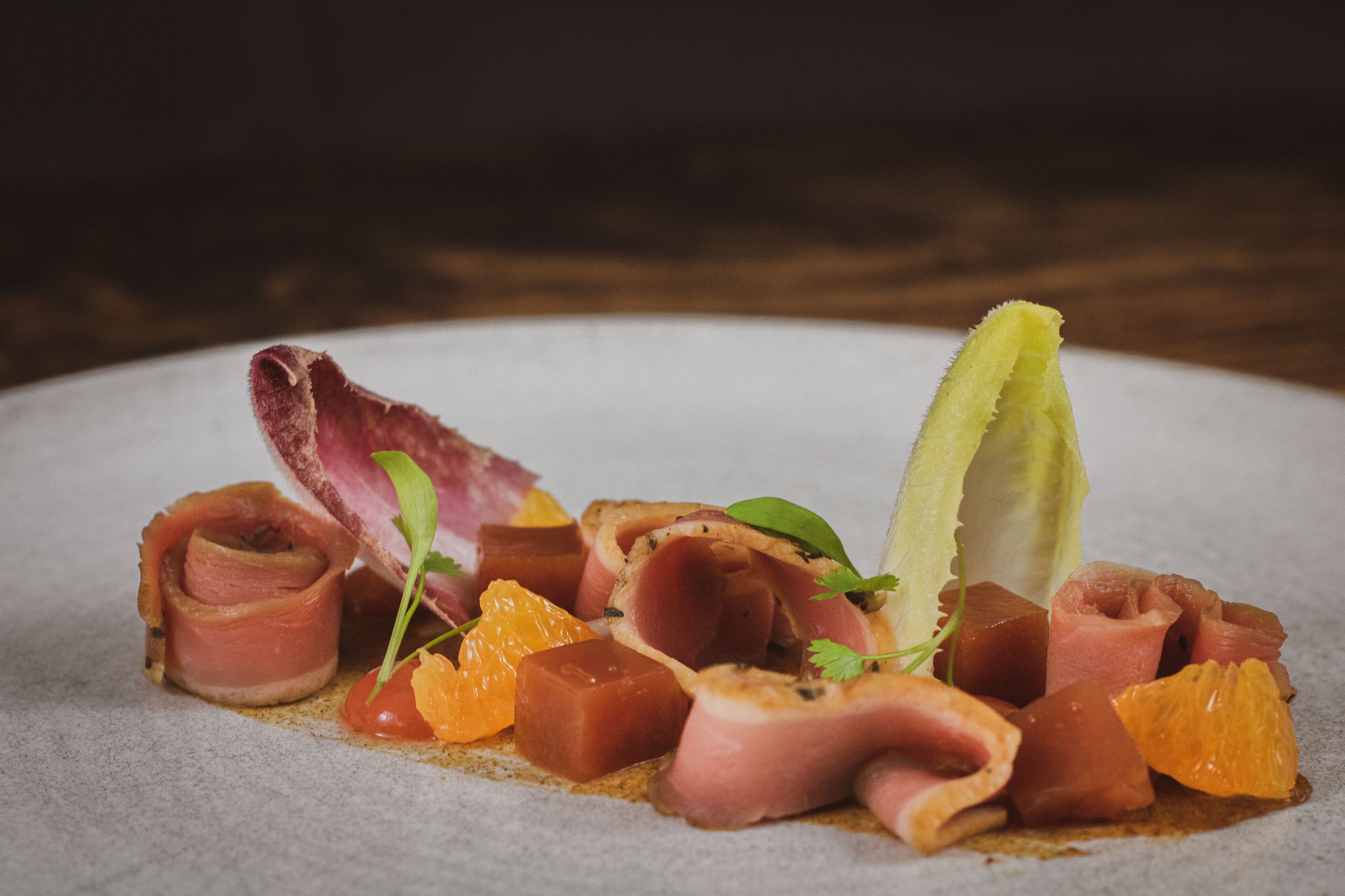 A plate of food with various meats and citrus fruits.
