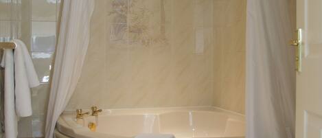 A bathroom with a bathtub, a shower curtain, and a towel rack.