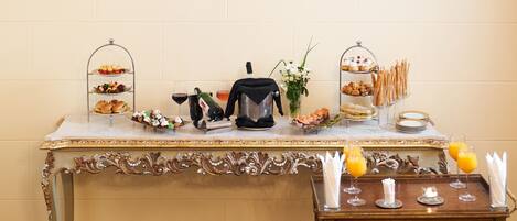 A buffet table with various food items, a coffee machine, and juice glasses.