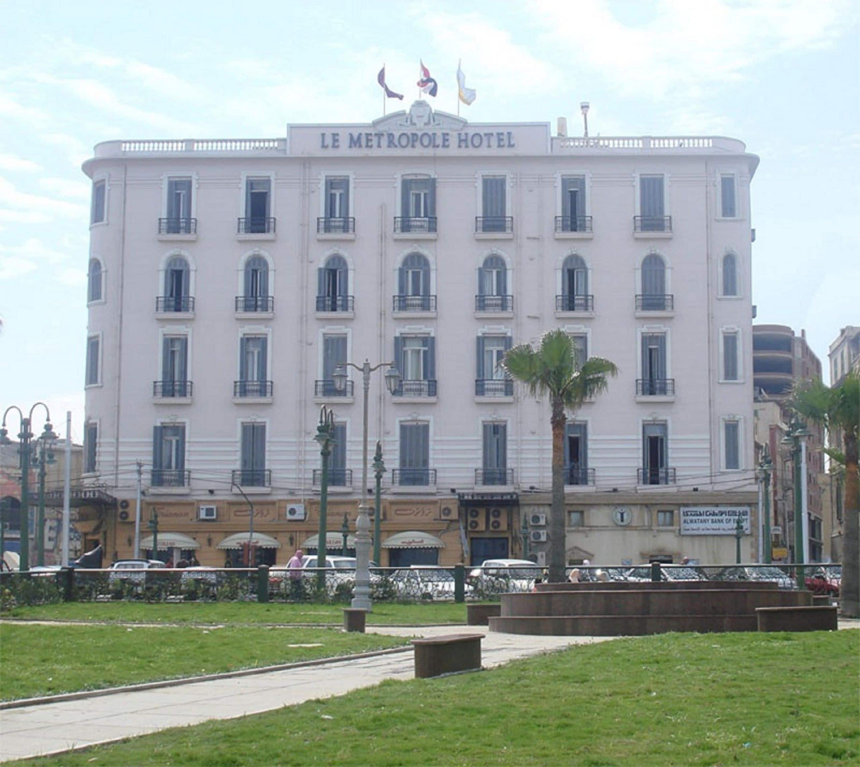 A large, multi-story hotel with a classic architectural style, featuring a central entrance and multiple balconies.