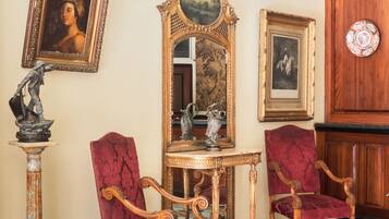 Una stanza con arredi elaborati, pavimento a scacchi e pannello decorativo.