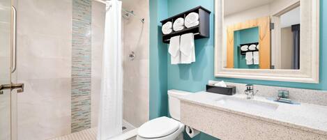 Un baño moderno con ducha, inodoro y lavamanos.
