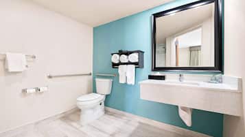 Een moderne badkamer met toilet, wastafel en handdoekhouder.