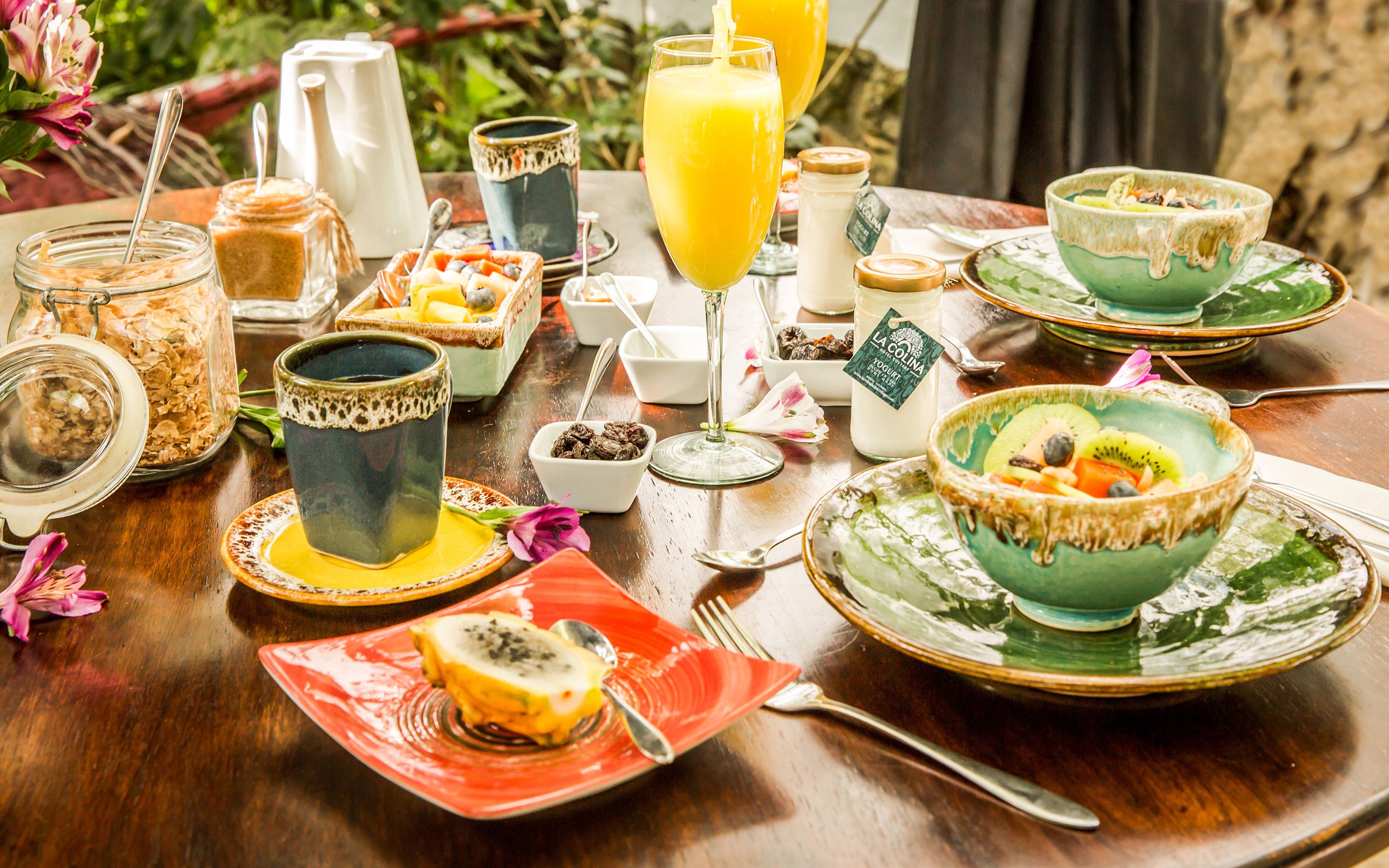 Una mesa de desayuno con diversas comidas, bebidas y utensilios.