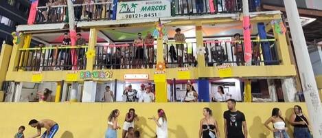 Un edificio de varios pisos con balcones, un letrero que dice 'Browllab' y un cartel con el nombre 'MARCOS'.