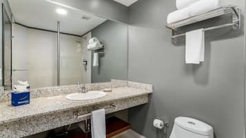 Ein Badezimmer mit Waschbecken, Spiegel, Handtuchhalter und Toilette.