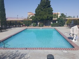 Una piscina al aire libre de temporada, tumbonas