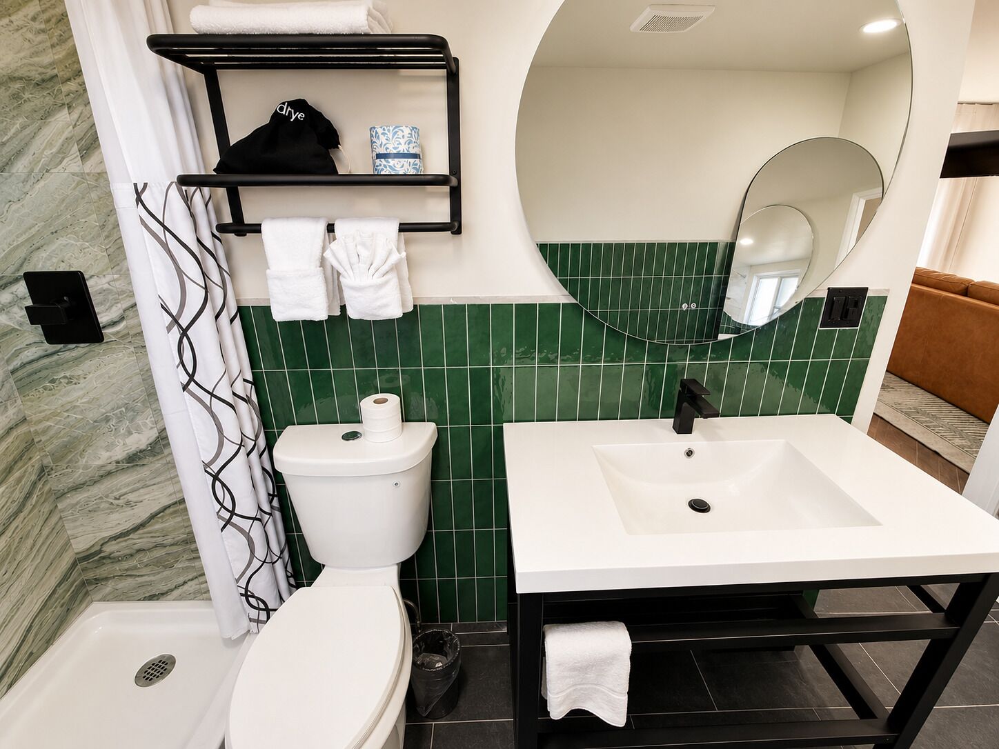 A bathroom with a toilet, sink, and mirror.