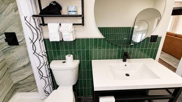 A bathroom with a toilet, sink, and mirror.