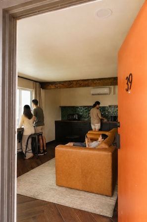 A modern interior with a kitchen, a living area with a sofa, and a dining table.