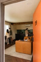 Un interior moderno con cocina, zona de estar con sofá y mesa de comedor.