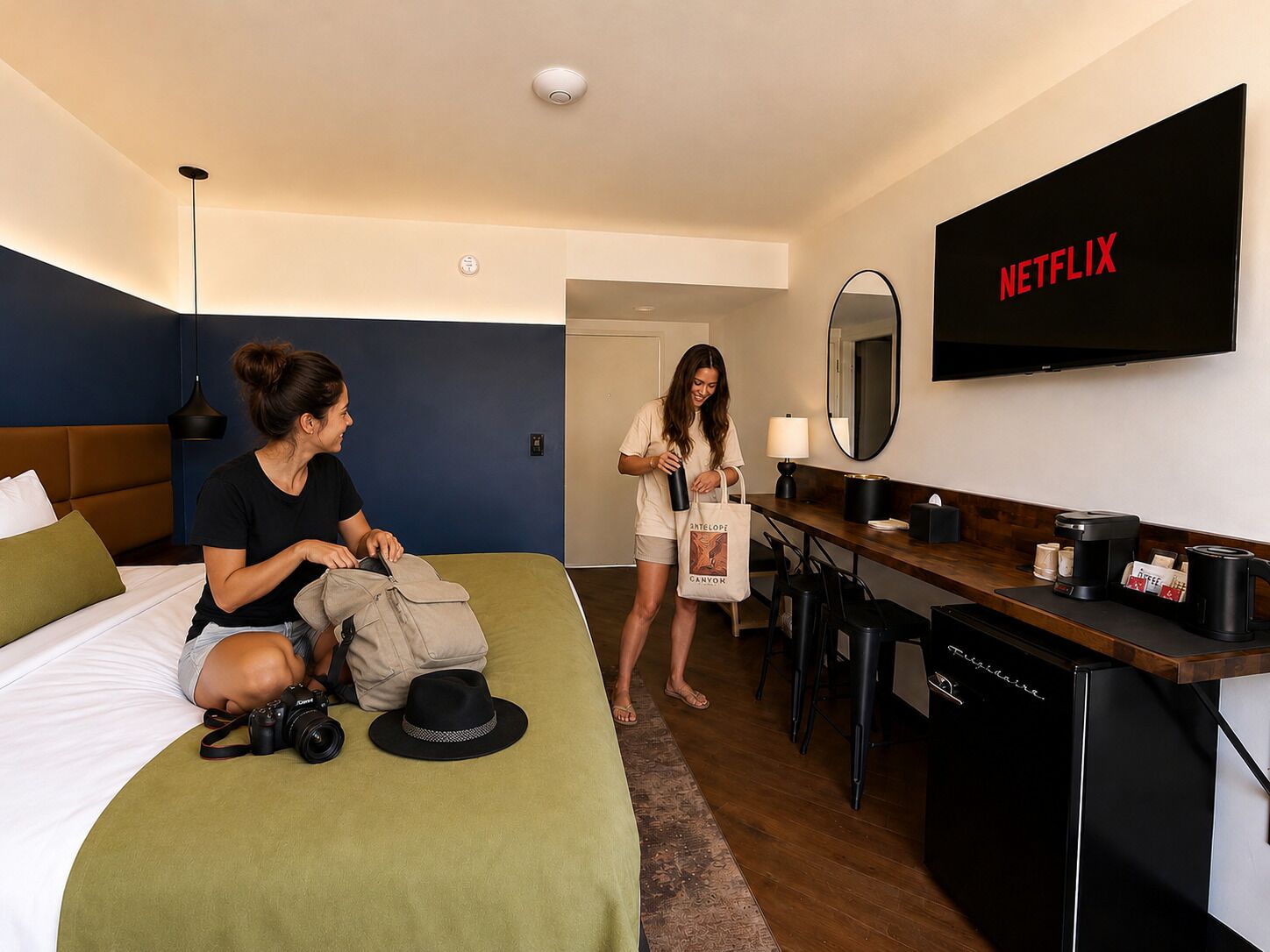 Une chambre d’hôtel avec un lit, un bureau doté d’une machine à café, un téléviseur affichant le logo de Netflix et une porte de salle de bain.