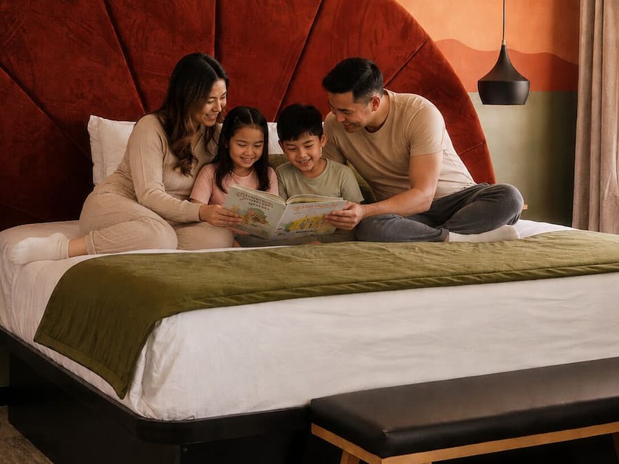 A bed with a large headboard, a bedside table, and a bench.
