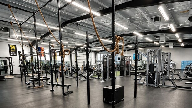 A gym with various exercise equipment, including weight machines and a pull-up bar. - The Wesley Hotel (Page)
