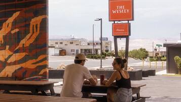 Un espacio de estar al aire libre con un letrero del restaurante 'The Wesley'.