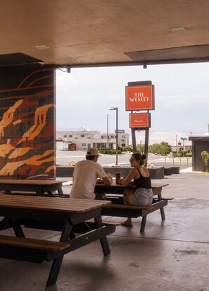 An outdoor seating area with a sign for 'The Wesley' restaurant. - The Wesley Hotel (Page)