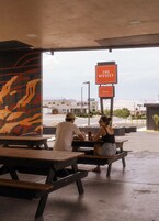 Un espacio de estar al aire libre con un letrero del restaurante 'The Wesley'.