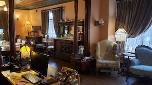A traditional room with a desk, computer, and vintage furniture.