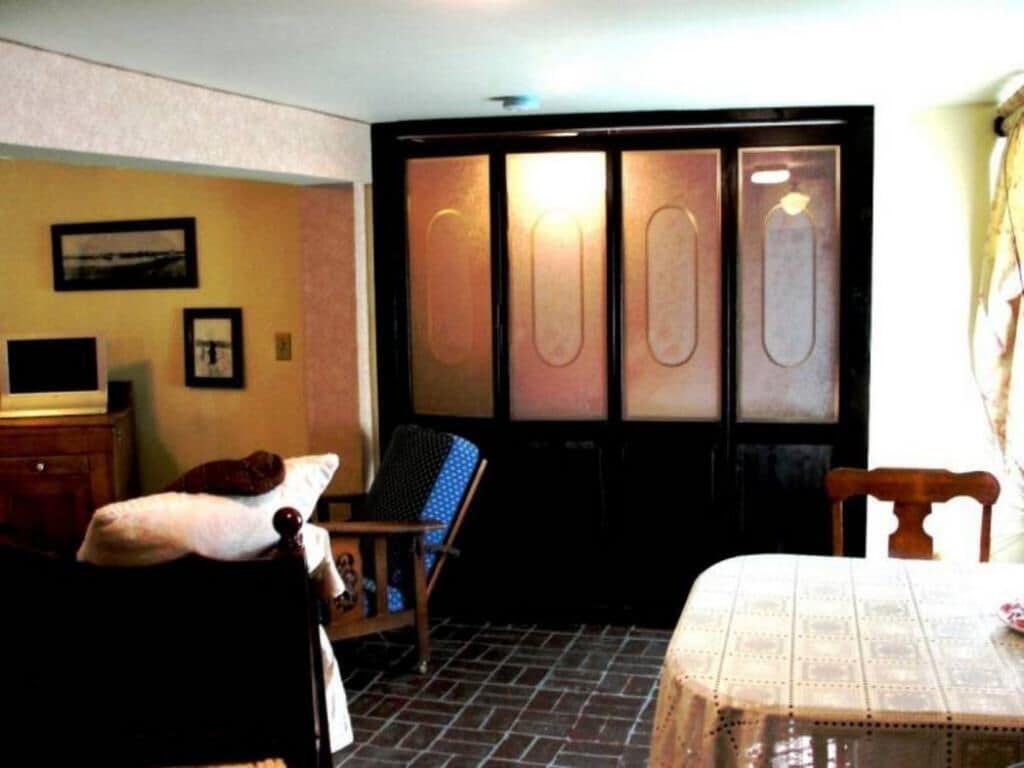 Ein Zimmer mit Bett, Stuhl, Tisch und Schrank.