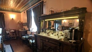 A traditional room with a wooden dresser, a mirror, and a small table with a lamp.