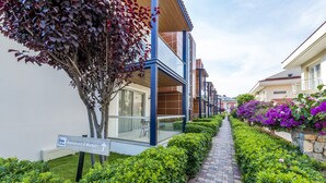 A pathway leading to a building with a sign indicating a restaurant and market. - Diana Residence (Fethiye)