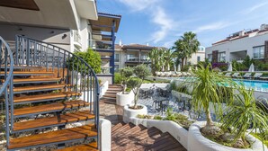 A poolside area with a wooden staircase, outdoor seating, and a pool. - Diana Residence (Fethiye)