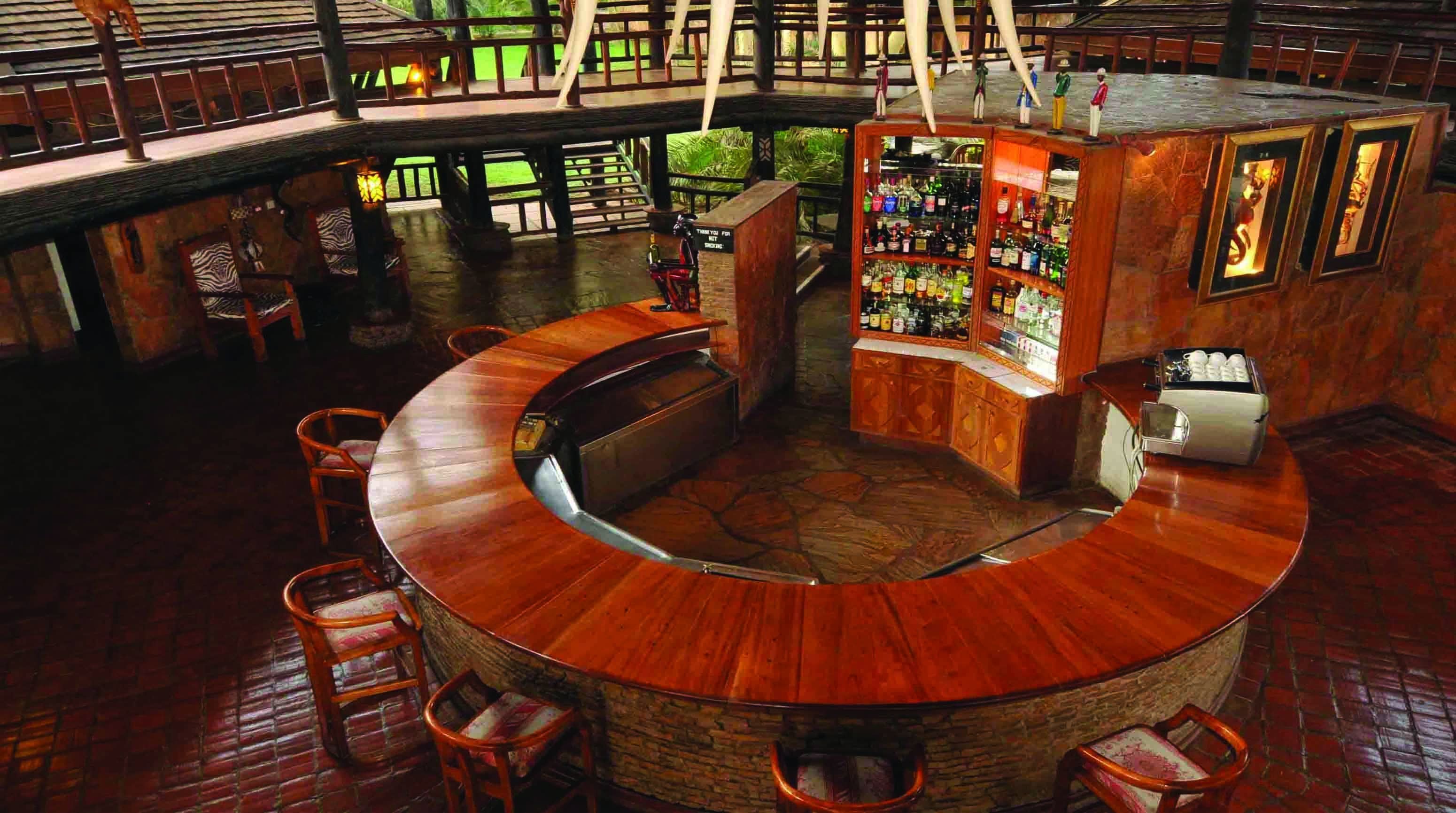 A circular bar area with a wooden counter, bar stools, and a seating area.