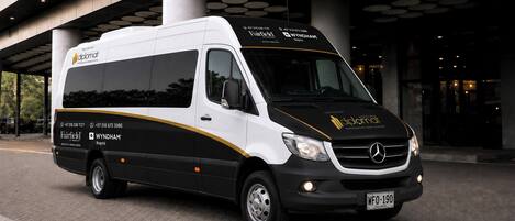 A white and black van with 'Fairfield' and 'Wyndham' branding, parked in front of a building with circular light fixtures.
