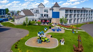 A hotel with a playground, outdoor seating, and a large building with multiple balconies.