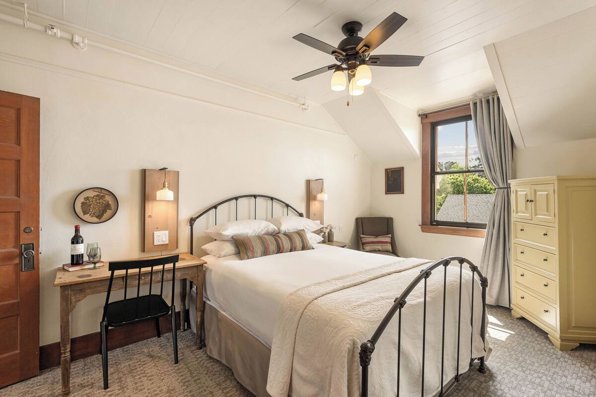 Une chambre à coucher comprenant un lit, un bureau, une chaise et une armoire.