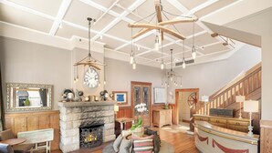 Un salón espacioso con chimenea, suelo de madera y un techo alto con vigas a la vista.
