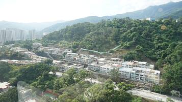 A residential area with multi-story buildings, a road, and surrounding greenery.